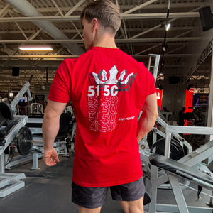 Man wearing red gym t-shirt with '51 50' graphic back design, showcasing fitness apparel in workout setting